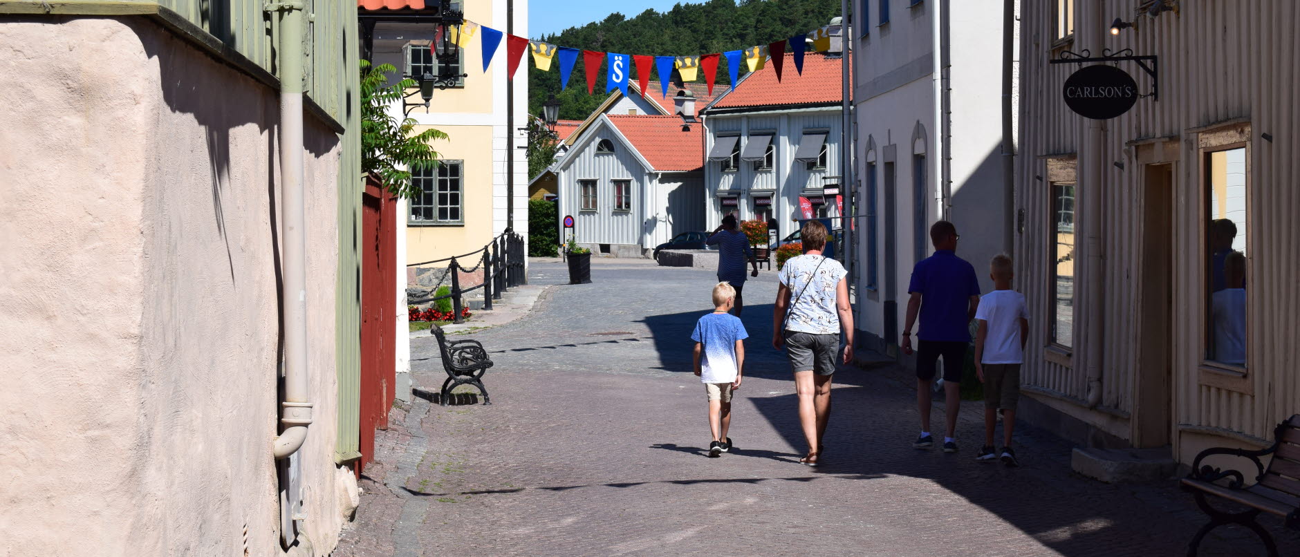 Bild visar en familm som går längs affärsgata i Söderköping