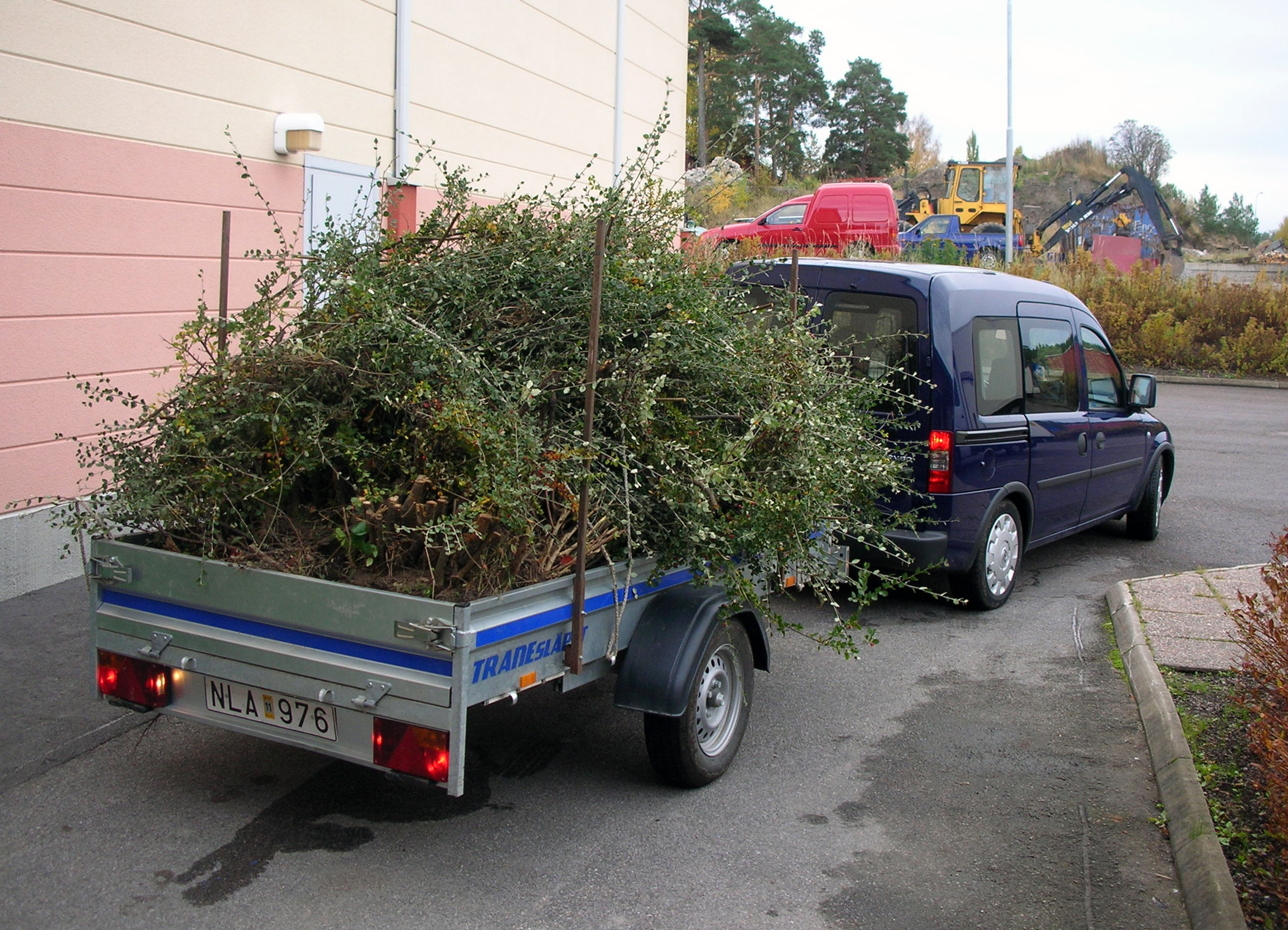 Bilden visar en bil med ett sl&auml;p som &auml;r fyllt med gr&ouml;na v&auml;xter