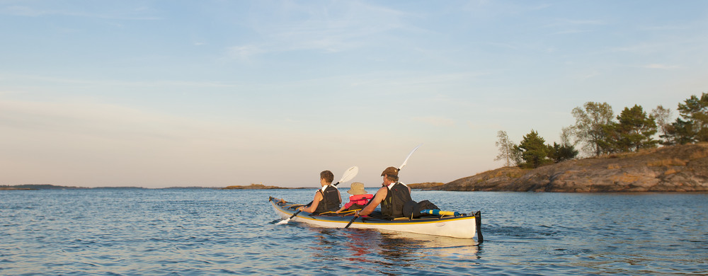 Bild visar tre personer i en kajak i Sankt Annas skärgård.