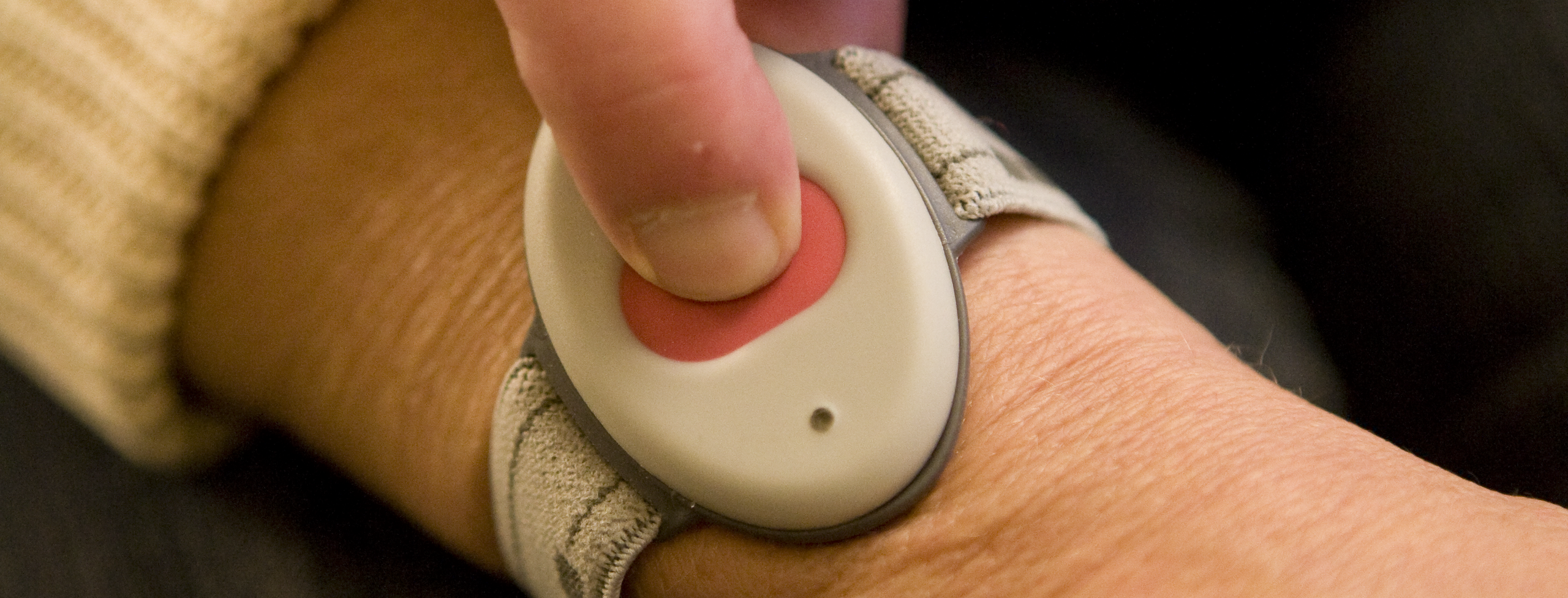 En person som trycker på sitt trygghetslarm