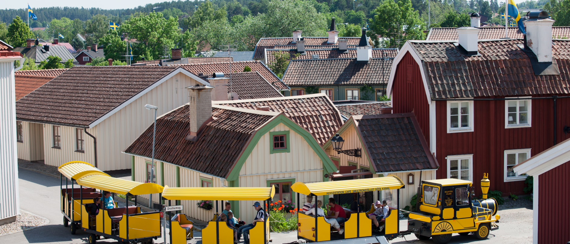 Tuffetåget kör genom ett somrigt Söderköping