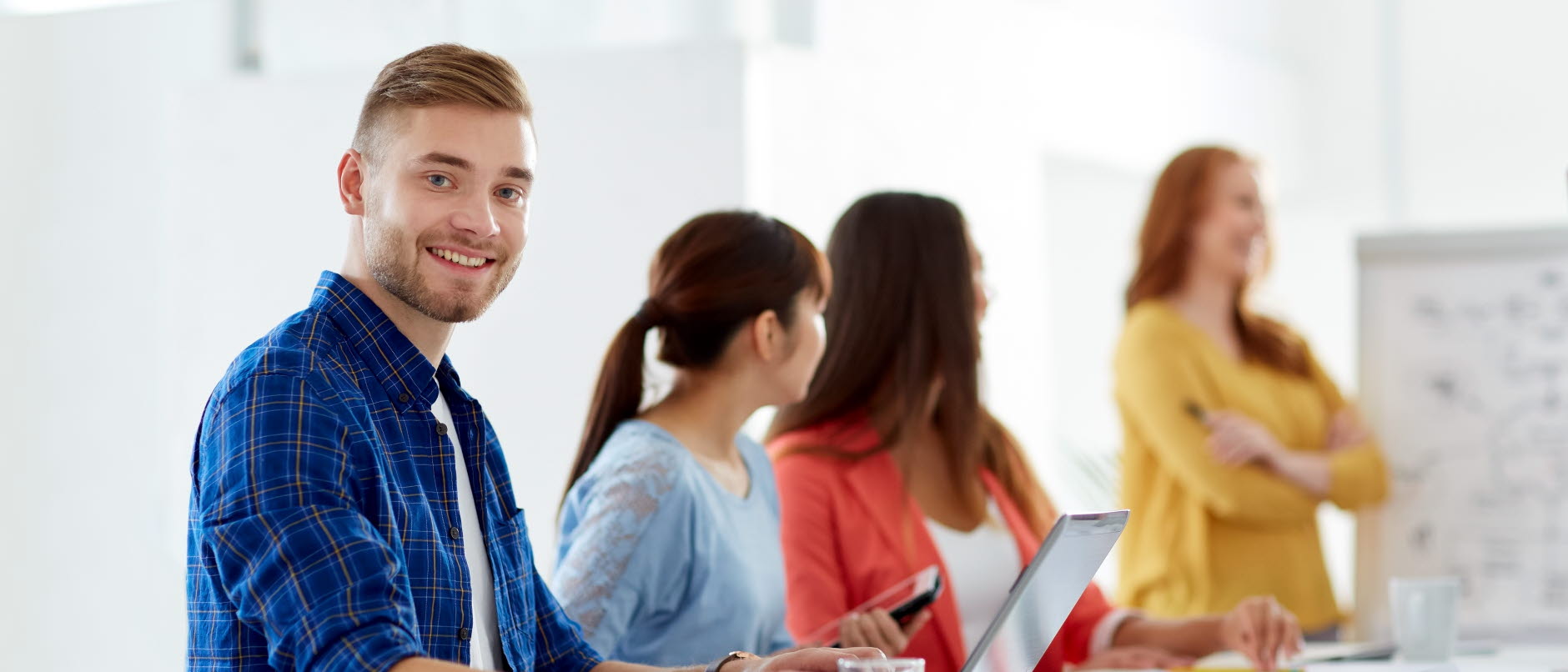 Unga glada människor på en arbetsplats